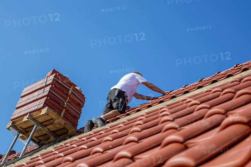 Roofers covering a tiled roof