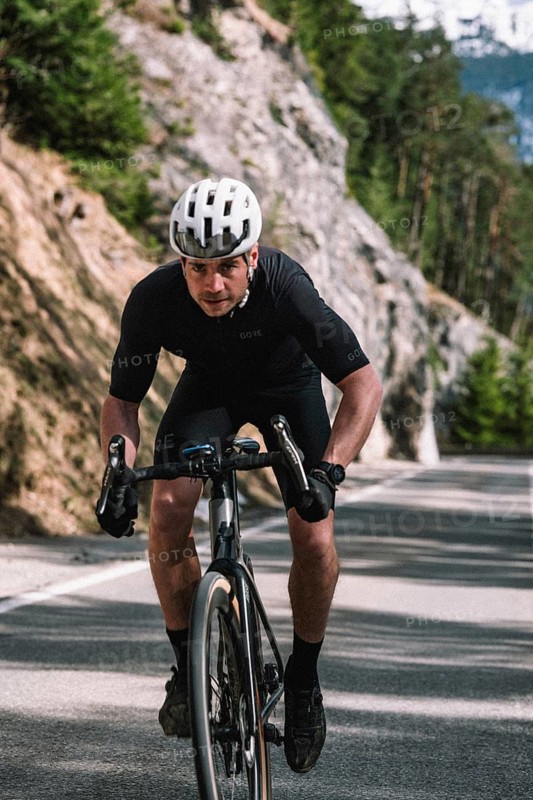 Road bike rider in spring in the Allgäu against the picturesque backdrop of the Alps, Bavaria, Germany