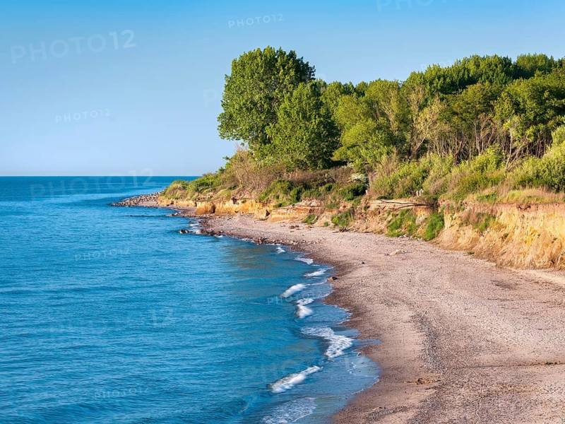 Unspoiled secluded coast of the Baltic Sea with natural beach and cliffs under blue skies in summer, Rerik, Mecklenburg-Western Pomerania, Germany