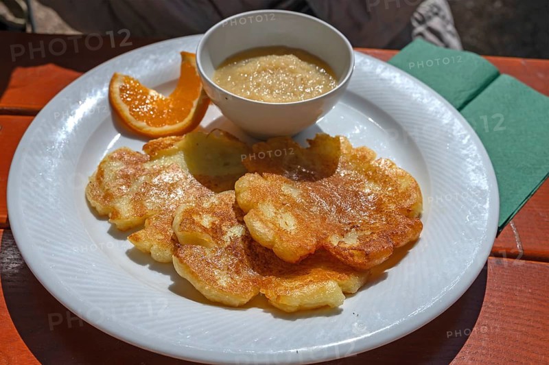 Baggers serving potato pancakes with applesauce in a garden restaurant, Franconia, Bavaria, Germany