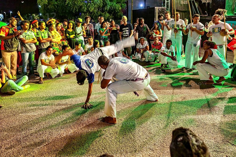 Capoeira artists on the move, accompanied by drumbeats and a large audience, The Capoeira combat dance at a small festival in Petrolina Brazil