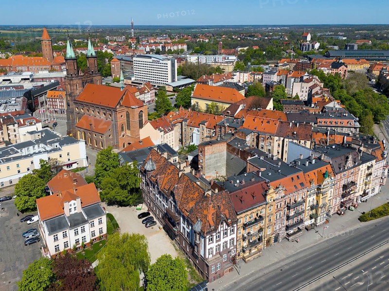 Aerial view of a historic town with red roofs and brick buildings, surrounded by green trees and roads, aerial view, Church of Our Lady on the left, row of houses on Witelona Street, Legnica, Liegnitz, Lower Silesia Voivodeship, Poland
