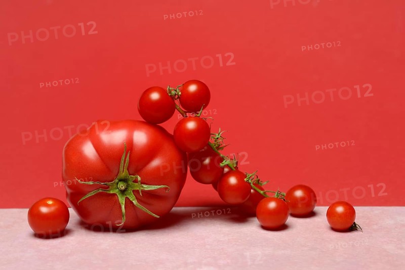 Beef tomato and cherry vine tomatoes with red background