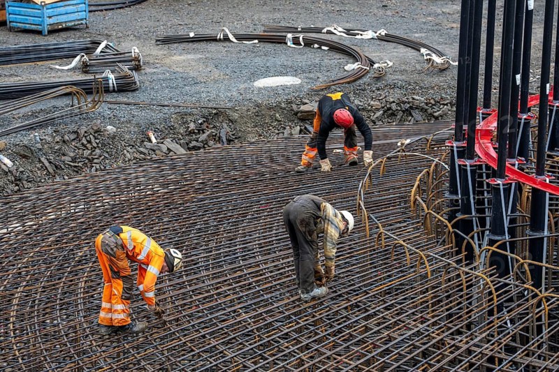 Assembly of reinforcing steel for the reinforced concrete foundation of a wind turbine, a mesh of rebar and reinforcing steel mesh, connecting the steel elements with binding wire, twisting with tongs, over 100 tons of reinforcing steel were used, the wind turbine will have a hub height of 160 meters, part of a new wind farm in Sauerland, near Balve, North Rhine-Westphalia, Germany