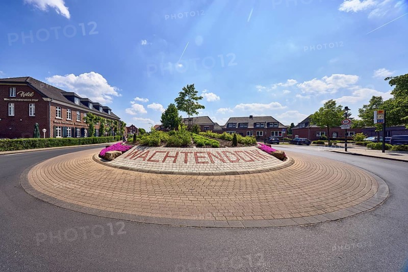 Roundabout, colored concrete paving stones, Wachtendonk lettering, flower bed, road, asphalt, general architecture, building, blue sky, cumulus clouds, roundabout between Bergstraße, Kuhdyck, Kempener Straße and Friedensplatz, Wachtendonk, Kleve district, North Rhine-Westphalia, Germany
