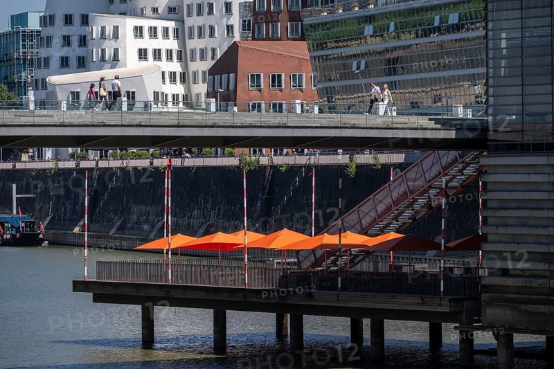 Building in the media harbor in Düsseldorf, terrace of the Lido-Hafen restaurant, Neuer Zollhof, Gehry buildings, modern residential and office buildings, as well as old port buildings, various industries, lots of catering, creative industries, fashion, media, advertising, North Rhine-Westphalia, Germany