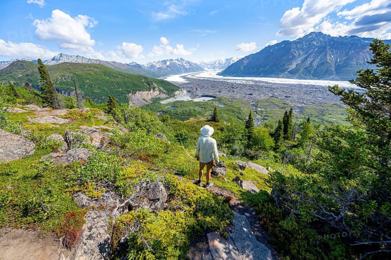 Young man enjoying the view, view of impressive mountain landscape with Matanuska glacier and glaciated mountain peaks, Lion's Head, Chugach Mountains, Alaska, USA