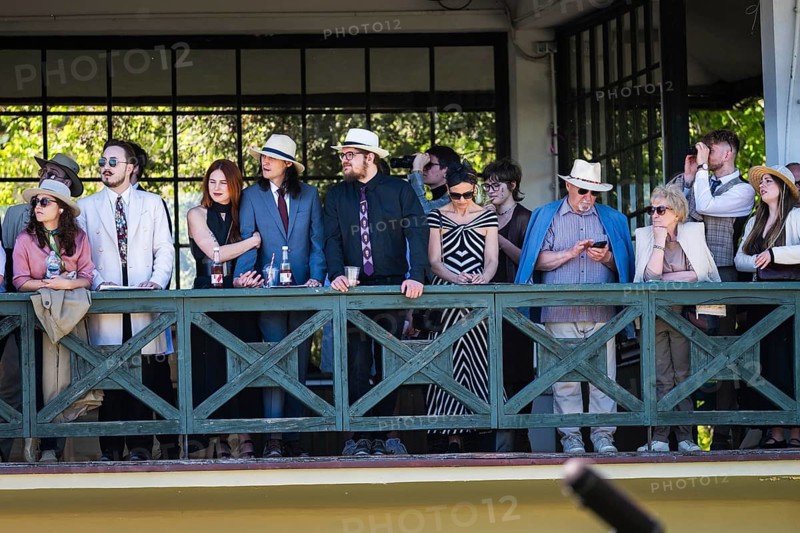 WROCLAW, POLAND - MAY 1, 2026: Horse race track WTWK Partynice. Crowd of elegant spectators wearing hats and formal clothes watching a horse race from a wooden gallery