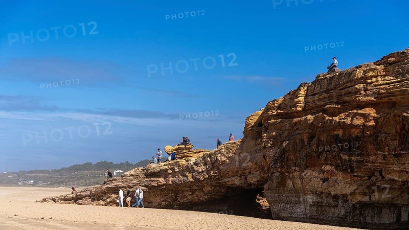 Tourists watch the waves of the Atlantic on the rocky plateau of Sito, also known as Forte São Miguel, a surfing paradise with monster waves in the months of November to February, Nazaré, Portugal