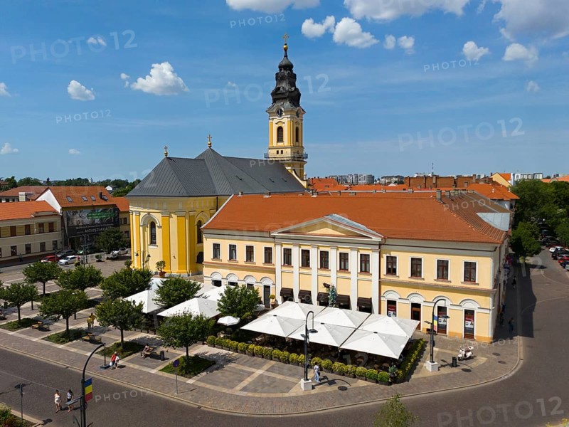 Baroque church and yellowish building on a sunny square surrounded by trees and urban flair, aerial view, St. Nicholas Church and Kovats House, Piata Unirii, Unity Square, Oradea, Oradea, Bihor District, Kreischland, Transylvania, Romania