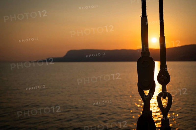 Part of the rigging of a sailing ship, anchoring, steel cables, back light, sunset, silhouette, bokeh effect, Sicily, Italy