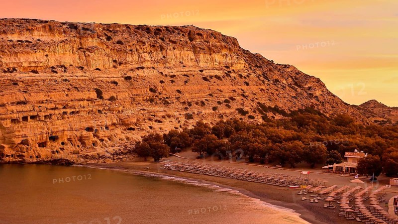 Neolithic caves, former hippie paradise, sunrise on a coast with rocks, quiet beach and a calm sea, Matala, south coast, Crete, Greek islands, Greece