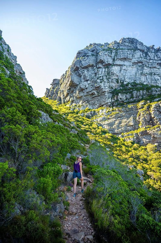 Kasteelspoort hiking trail, young woman hiking on a trail through a rocky, green landscape under clear sky, Eastern Cape, Table Mountains, Cape Town, South Africa