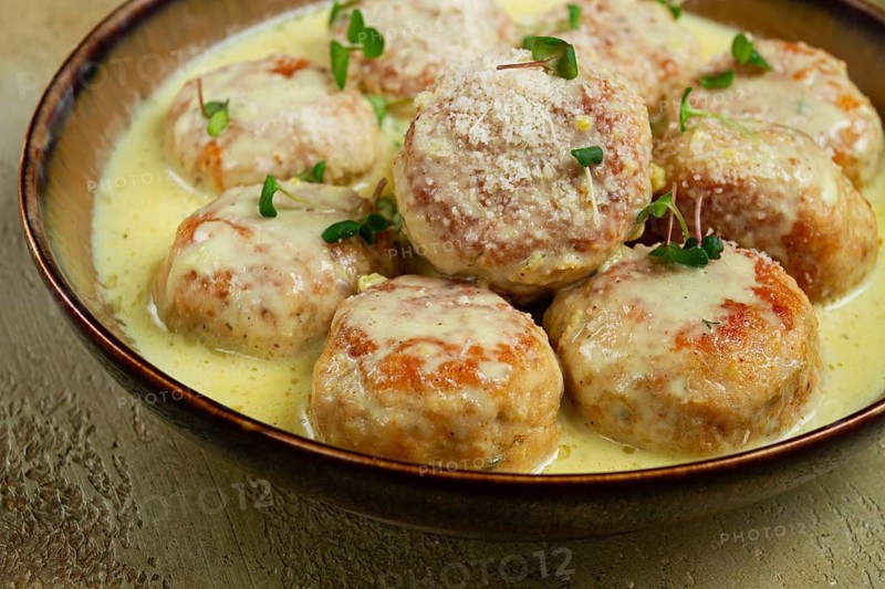 Chicken meatballs, in cream sauce, garnished with parmesan cheese, and microgreens, homemade, no people