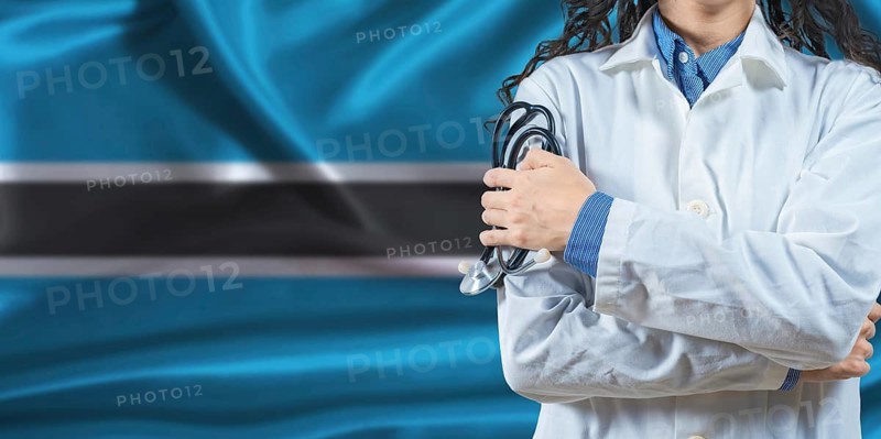 Healthcare professional with Botswana flag background. Professional doctor holding stethoscope on Botswana flag background