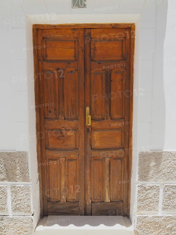 Rustic wooden door with golden door handle in white facade, Fataga, Barranco de Fataga, Gran Canaria, Spain
