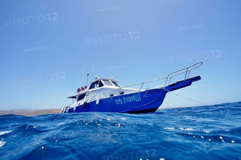 A dive boat floats on the blue sea surface, meteor wreck dive site, Russian hydrofoil ferry, Arguineguin, Gran Canaria, Spain, Europe, Atlantic