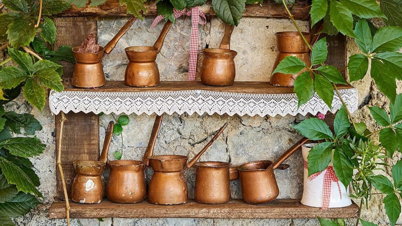Decorative copper pots arranged on a shelf with plants, tavern, Meronas village, Meronas, Amari Basin, Central Crete, Greek Islands, Greece