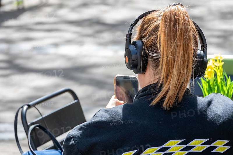 Young woman with headphones and cell phone, Bavaria, Germany