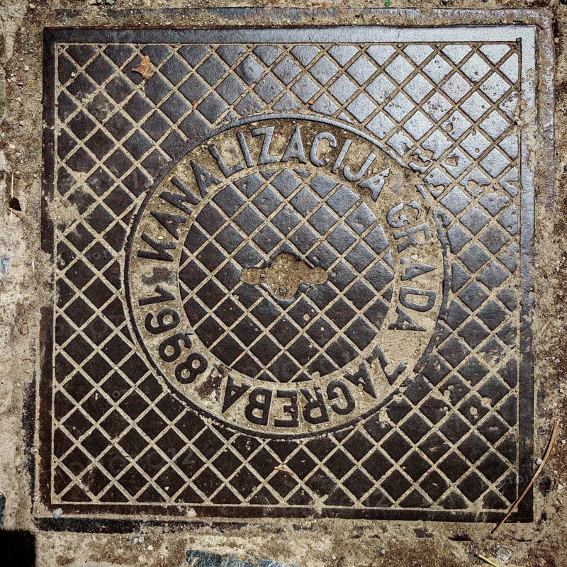 An old metal manhole cover in Zagreb shows a grid pattern, Zagreb, Croatia