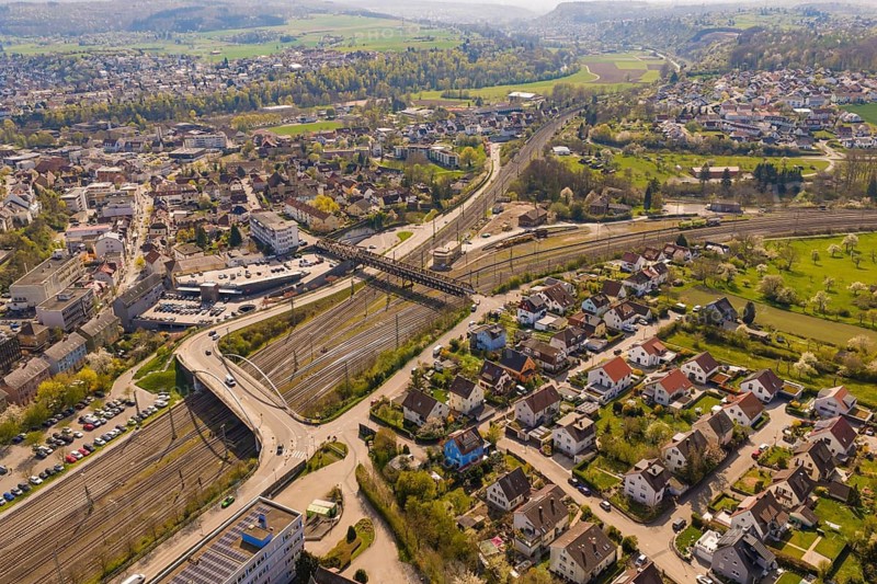 View of a city with branched railway lines and surrounding residential areas in a hilly landscape, PV plant at Obi Baumarkt, Mühlacker, Enzkreis, Germany