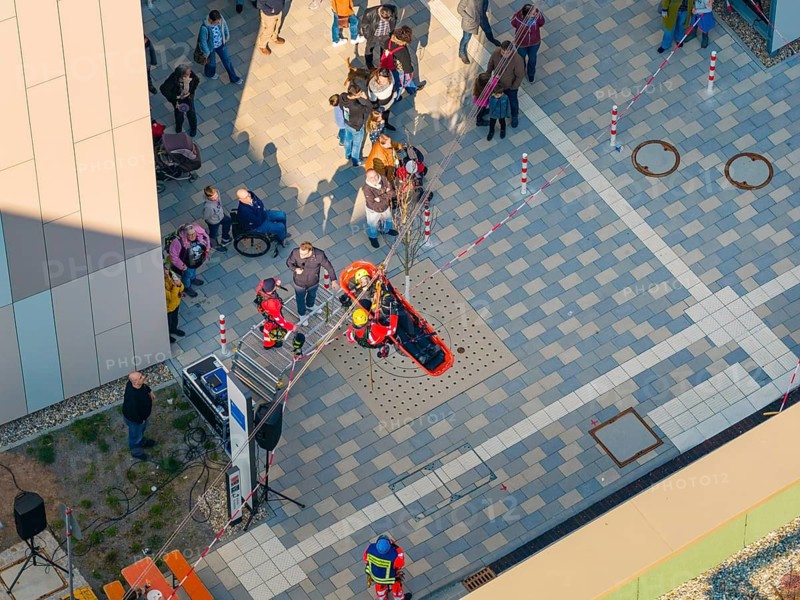 People on a paved square at an event with marked areas, hospital opening, Calw, Germany