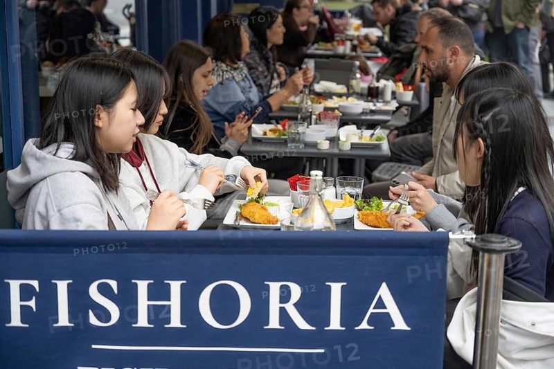 London, United Kingdom. April 17th 2026. Foreign tourists eating fish and chips in a central London restaurant, the most famous of British food sold all over the UK