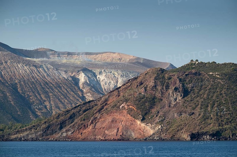 Craters with sulfur vapors seen from the sea, rocky coast, Vulcano, Aeolian or Lipari islands, Sicily, southern Italy, Italy