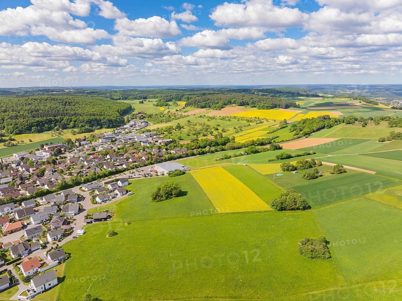 Aerial view of a farming village with wide fields and a lively sky, Gechingen, Black Forest, Germany