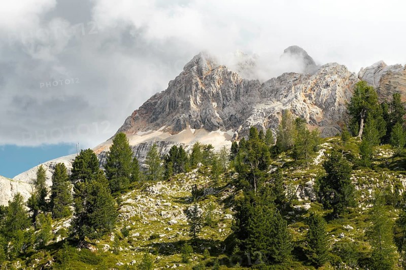 Dramatic mountain peaks colorful rocky scree slopes scenic alpine vista cloudy overcast sky mountain range background Malga Rossalm Dolomites South Tyrol Italy summer travel landscape