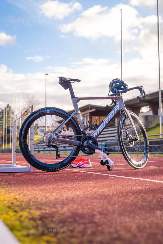 Grey racing bike on a red track with sunny sky in the background, triathlon bike, Calw, Germany