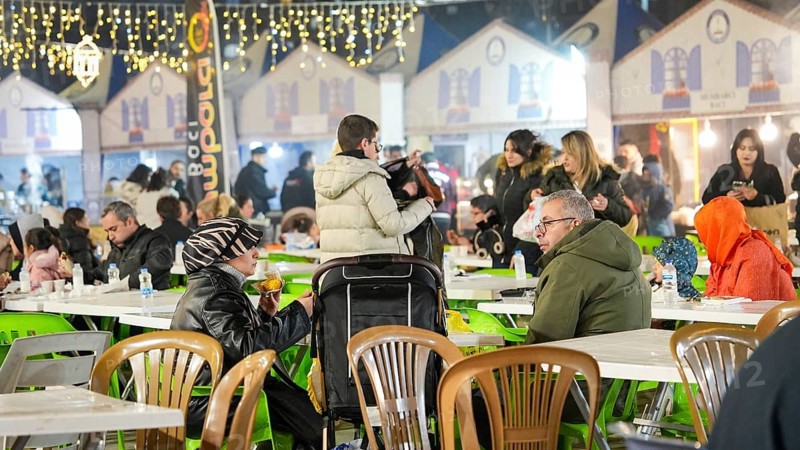 Muslim families and individuals gather at outdoor tables for a mass community Iftar meal under festive Ramadan lights in Gaziantep, Turkey on March 11, 2026, Gaziantep, Turkey