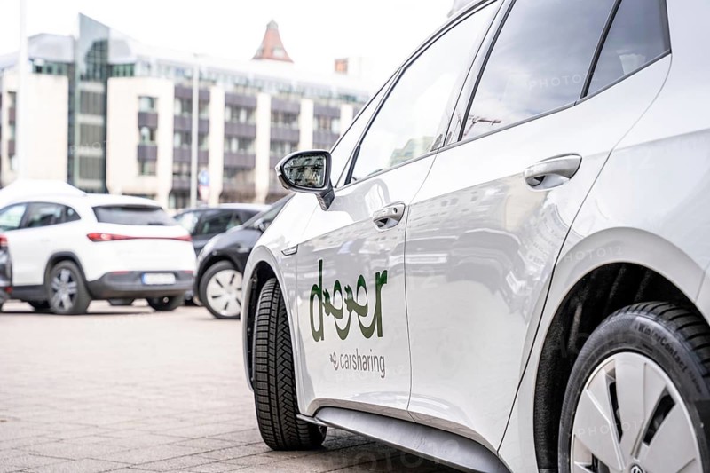 Side close-up of a white carsharing electric car with urban background, Deer, E-Carsharing, Stuttgart, Germany