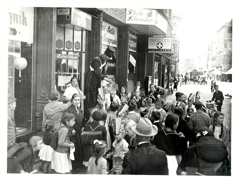 Photo shop, children, with promotional caps, Zeiss-Ikon, shop, work, twenties, crowd in front of a shop, in the middle of a street party with historic signs, around 1928