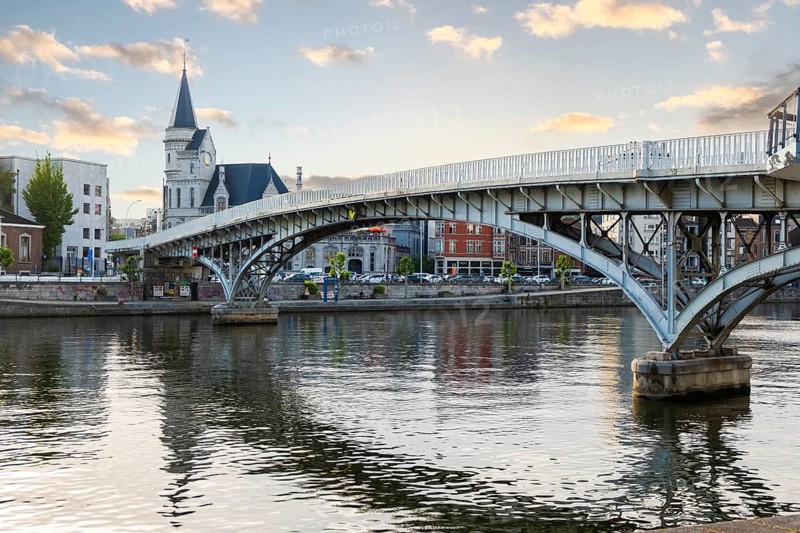 A curved footbridge across the river Maas, view of the building Die Große Post, Liège, Belgium, digitally reworked