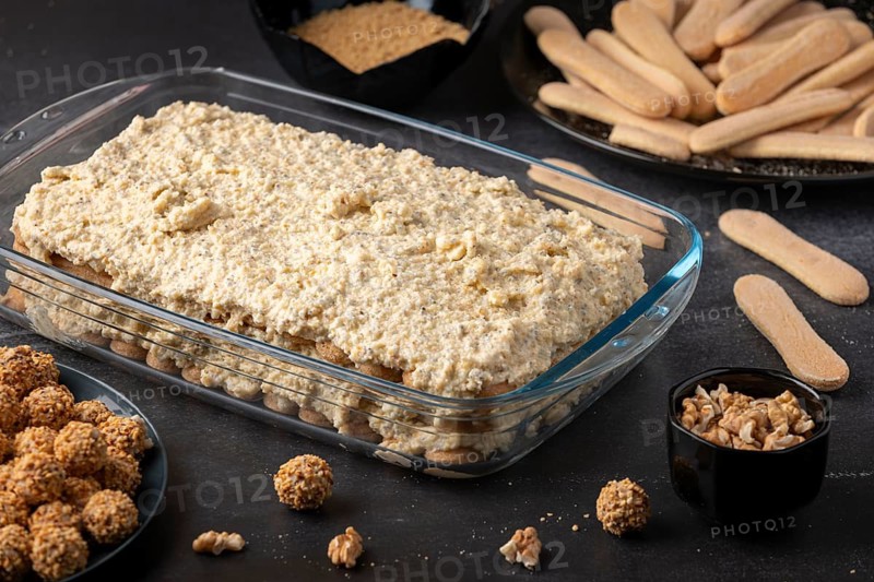 Ingredients for tiramisu, sponge cake and curd cream layered in glass form