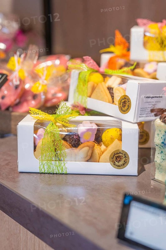 Gift boxes with colorful handmade cookies, decorated with yellow bows, presented on a table, Café Kuh, Deckenpfronn, Germany