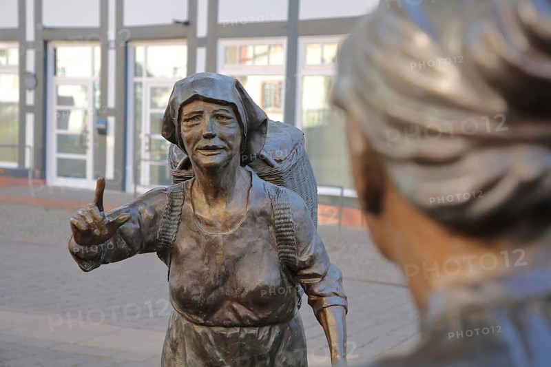 Market Women sculpture by Ewald Rumpf 2009, modern art, bronze sculpture, life-size, two standing woman with index finger, gesture, arm up, gossip, ear, listening, telling, communication, marketplace, Rotenburg an der Fulda, Hesse, Germany