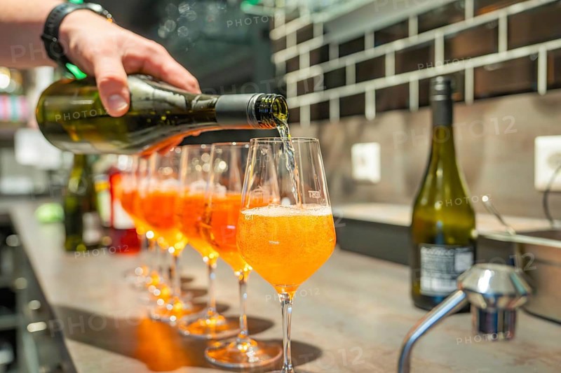A drink is poured into a series of aperitif glasses at a bar, Cafe Kuh, Deckenpfronn, Germany