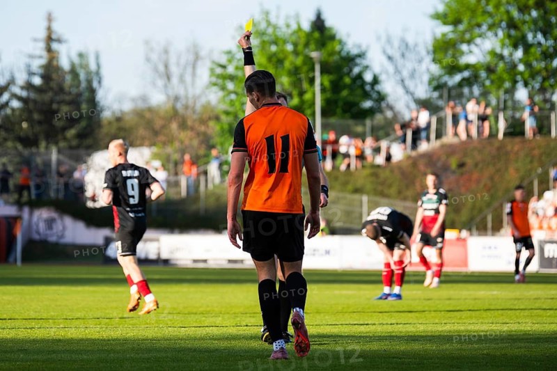 Referee showing a yellow card to a soccer player during a football match in a stadium in Glogow, Poland