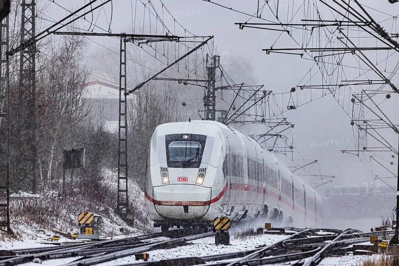 ICE traveling through a winter landscape in snowfall. A train on the line in the Deutsche Bahn Amstetten rail network, Baden-Württemberg, Germany