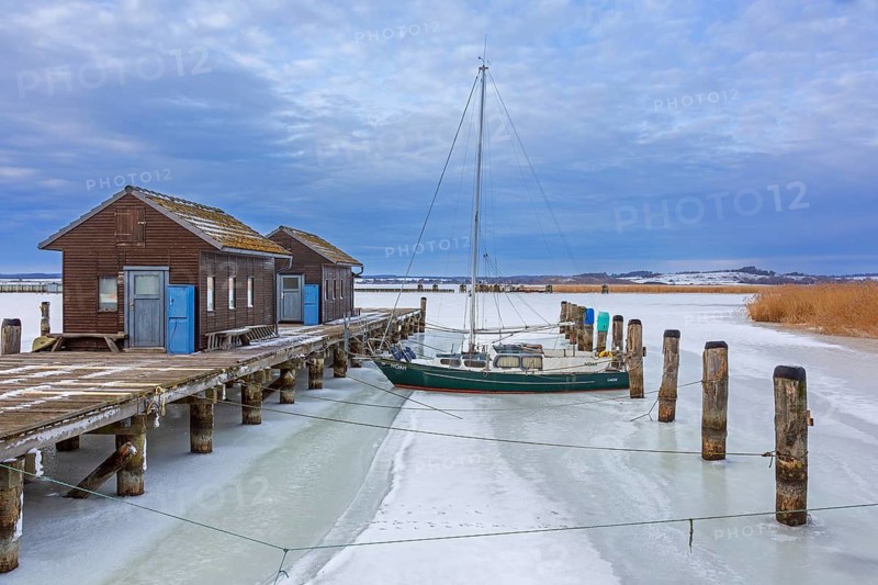 Boathouses on wooden jetty in the Gager harbour in winter, Mönchgut peninsula, Rügen Island, Mecklenburg-Vorpommern, Germany