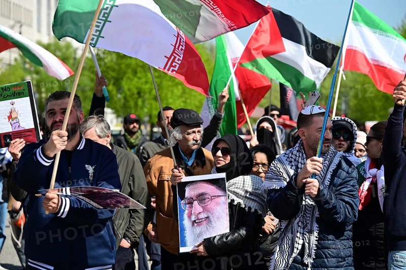 Opponents of Reza Pahlavi are protesting against Pahlavi's visit at Pariser Platz at the Brandenburg Gate. A demonstrator holds a photo of the killed Ali Khamenei