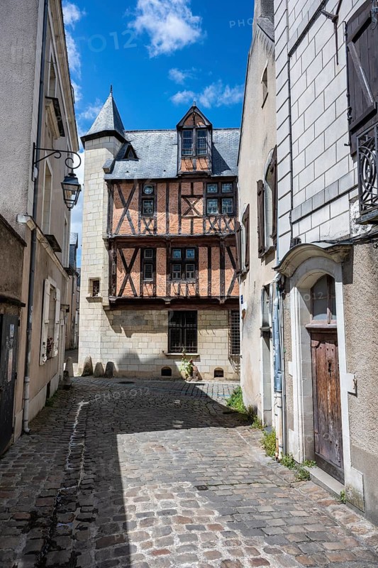 View through an old town alley to a well-preserved, heritage-protected half-timbered building with traditional architecture in the historic old town of Angers, Maine-et-Loire, Pays de la Loire, France