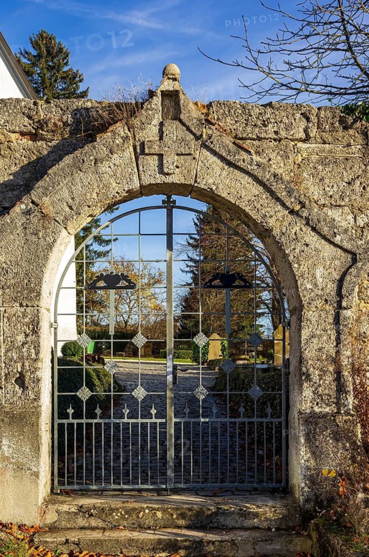 Cemetery gate at St. Stephen's Church in the desert of the village and today the ghost village of Gruorn on the former military training ground in the Münsingen estate district, Baden-Württemberg, Germany. Gate to the Churchyard of St Stephen's Church in the Abandoned Village and Present-Day Ghost Place of Gruorn on the Former Military Training Area on the Munsingen Estate, Baden-Württemberg, Germany