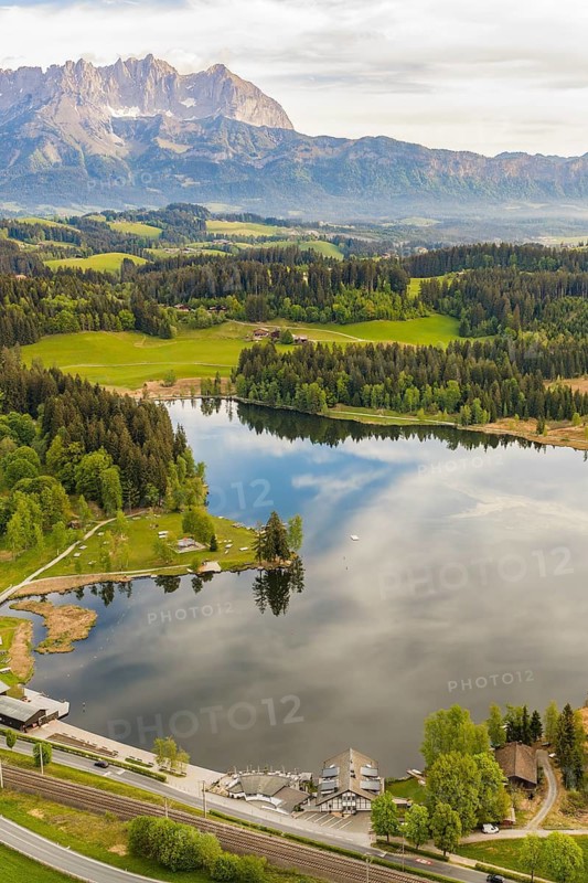 Panoramic view of quiet lake surrounded by mountains, Schwarzsee circular trail, Kitzbühel, Austria