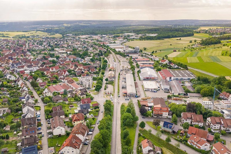 View of a city with tracks and buildings, surrounded by fields and forest, on the horizon, Hermann-Hesse-Bahn, Althengstett railway station, Calw district, Germany