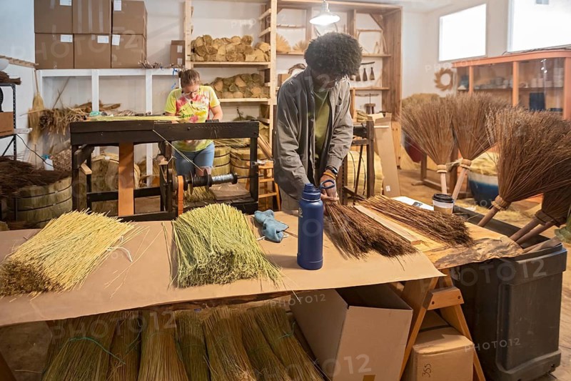 Berea, Kentucky - Aja Haynes (right) and June Rosenbarker make traditional Appalachian brooms and whiskbrooms, by hand at Sunhouse Craft. They use broomcorn, a type of sorghum, and distribute their products through wholesalers and direct to consumers