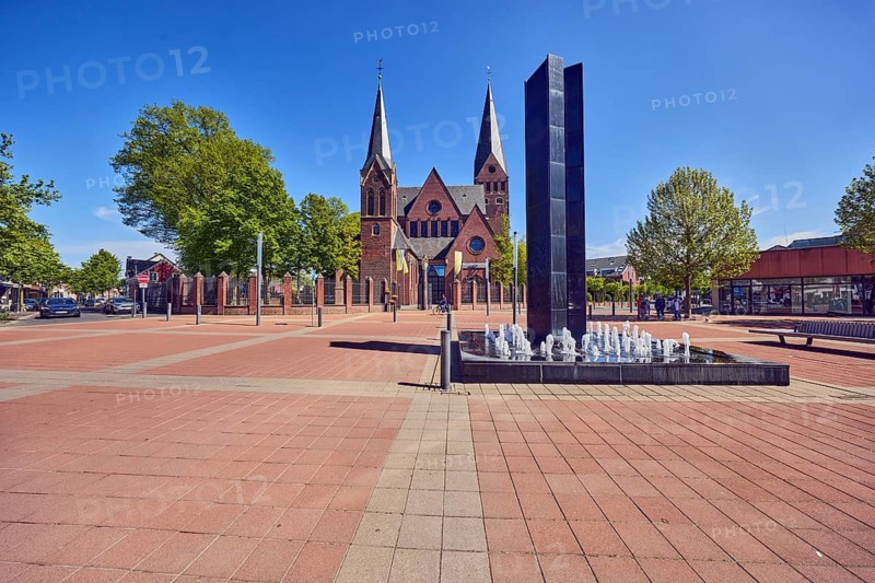 Black Fountain water feature, church tower, parish church, city center, square, barrier bollard, pedestrian area, trees, blue sky, cloudless, confluence of main street, Bahnstraße, Geldener Straße and Marktstraße in Roermonder Platz, Kevelaer, Kleve district, North Rhine-Westphalia, Germany