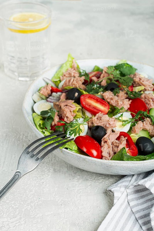 Salad with canned tuna, vegetable salad with quail eggs, lettuce and romaine leaves, red onion, cherry tomatoes, olives, keto food, healthy eating